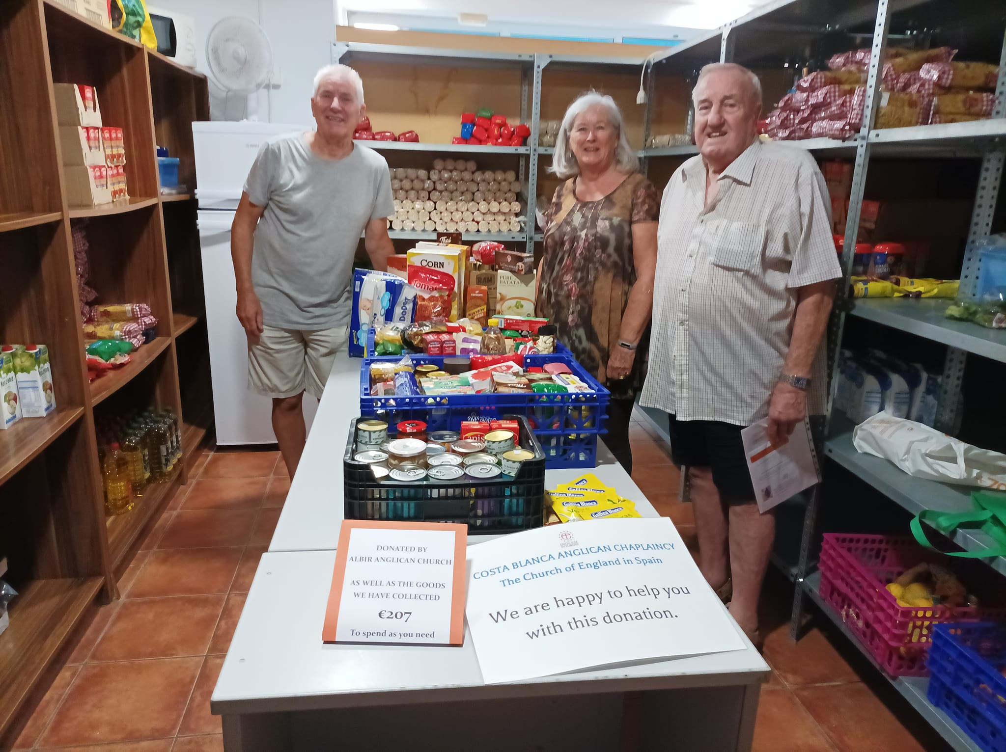 Three people surrounding harvest donations.