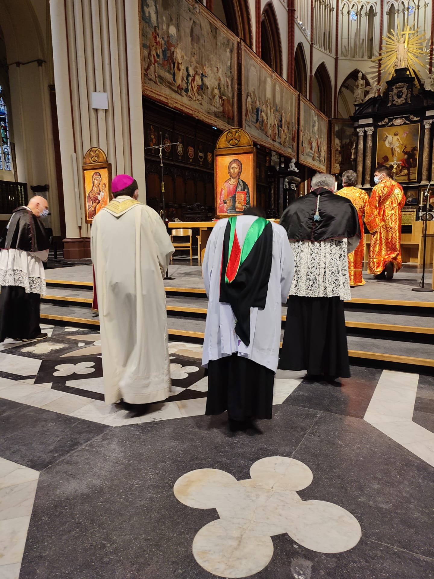 Clergy members walking to the front of a church.