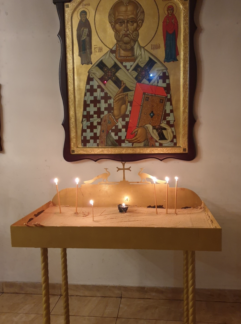 A wooden table with lit candles.