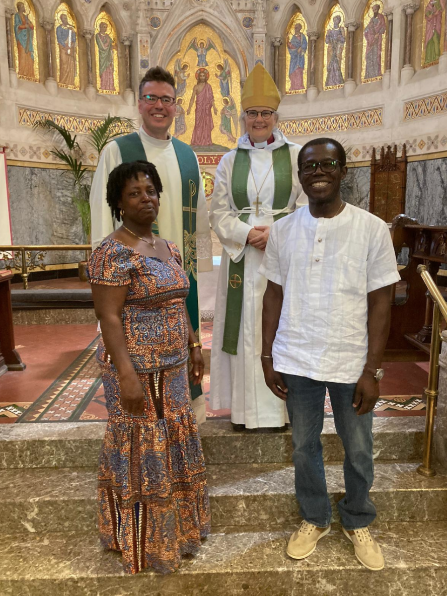 Four people posing inside a church.