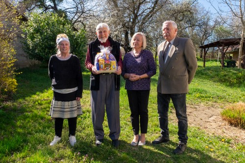 Three members of the Chaplancy and Revd Canon Denis Moss holding gifts.