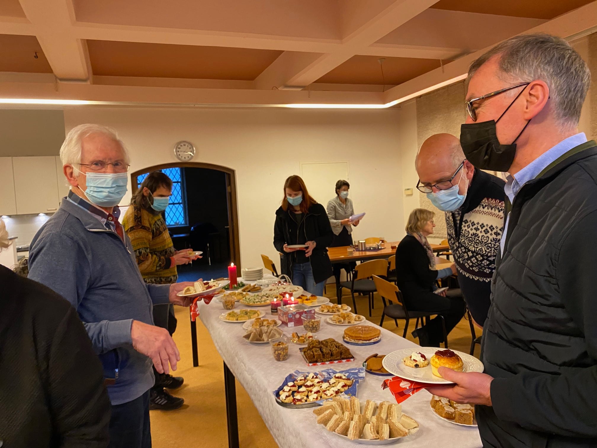 Men talking around a buffet table.