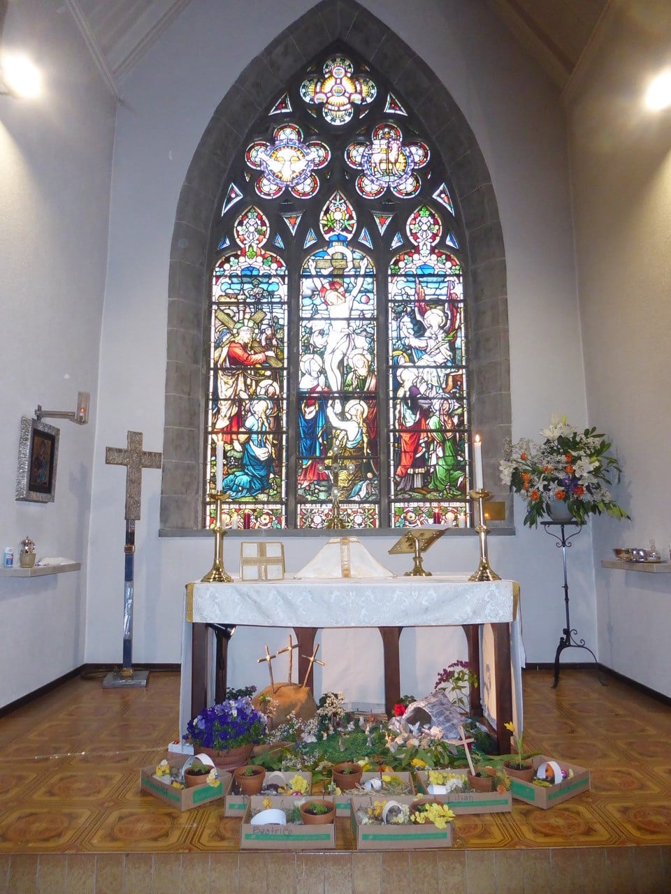 Easter donations infront of a large stained glass window.