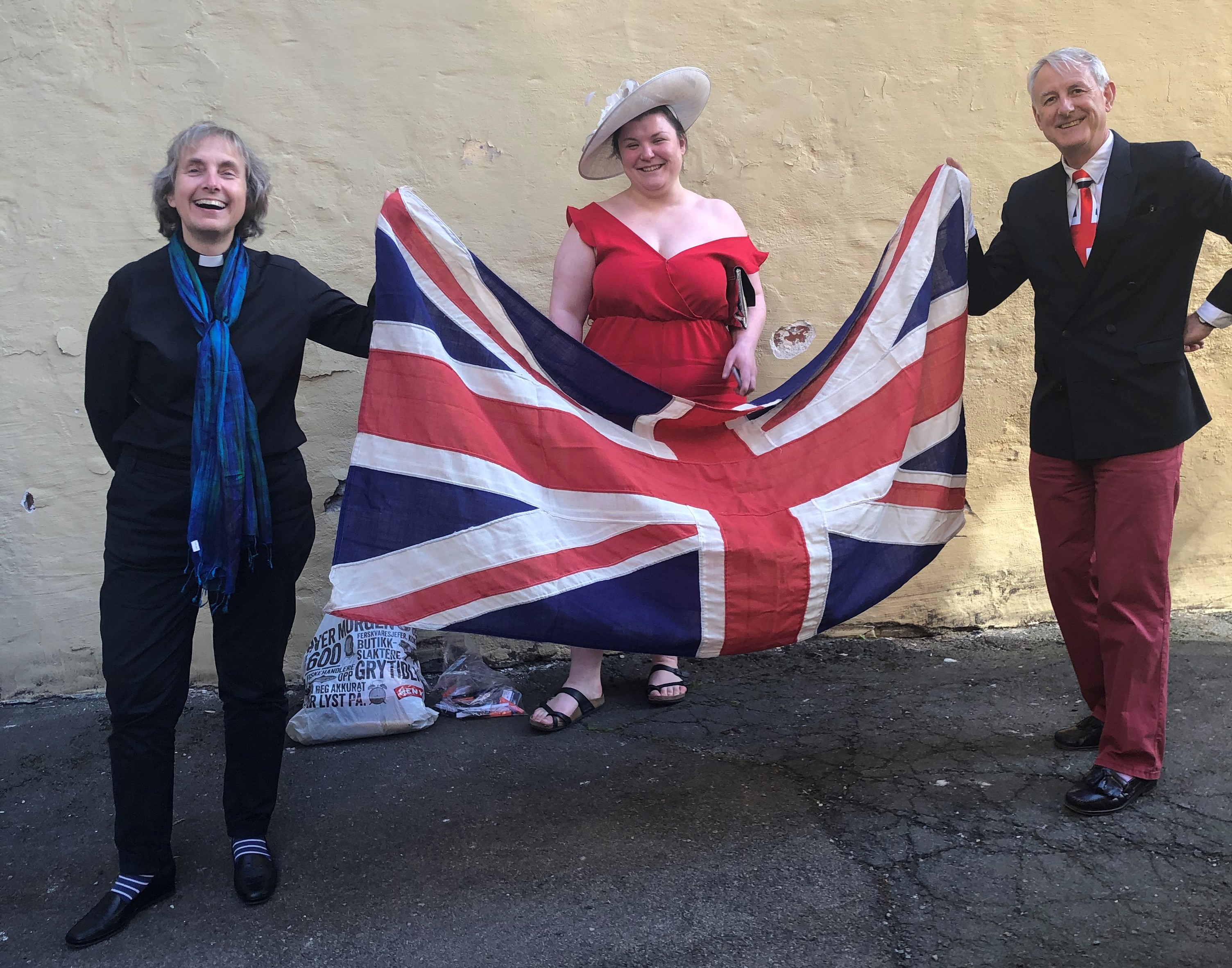 Three people holding up a union jack.