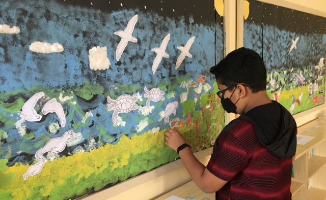 A child painting sea creatures in Barcelona.