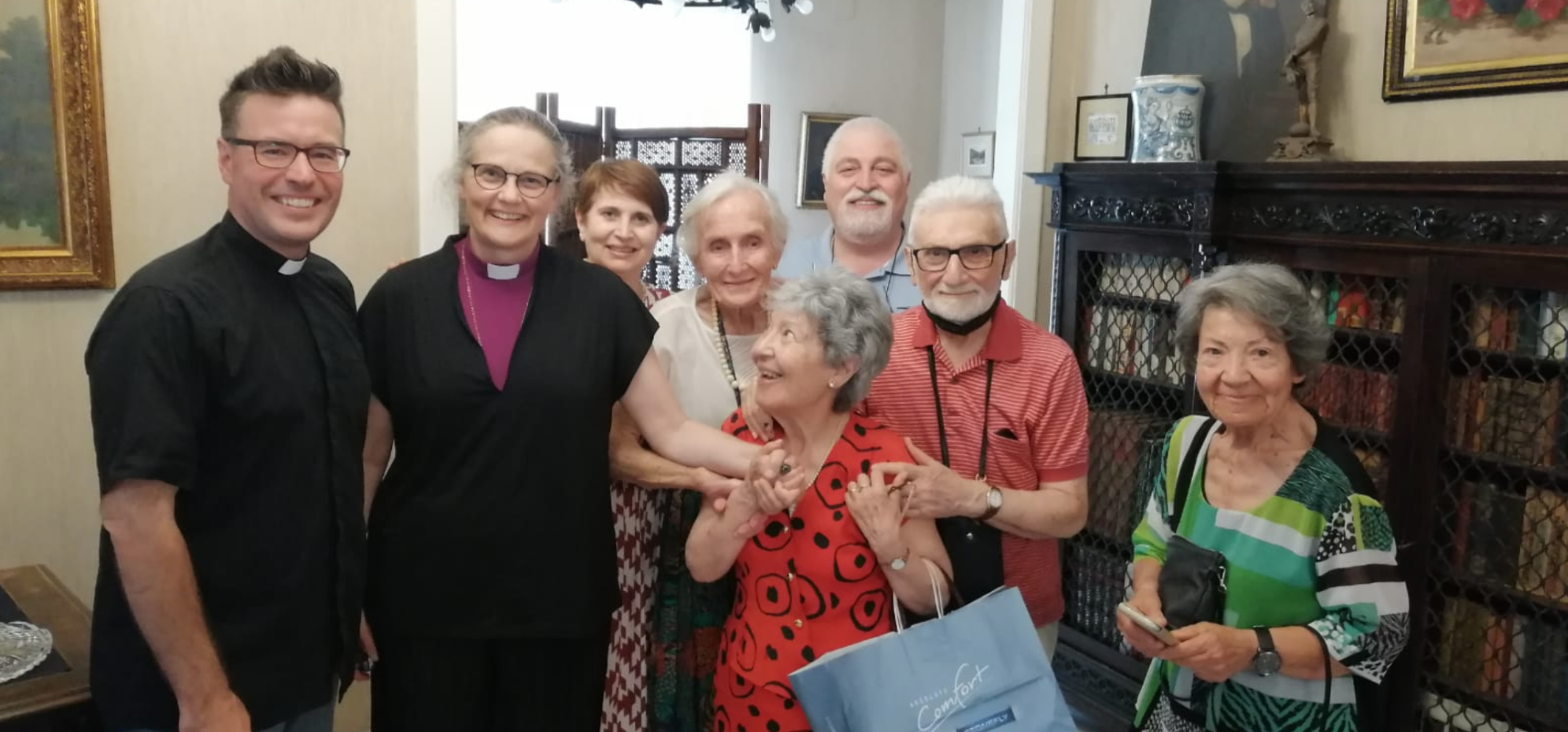 A group of smiling members of the Holy Cross church.