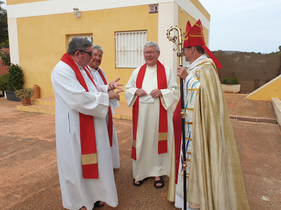 Bishop Robert talks to other clergy members.