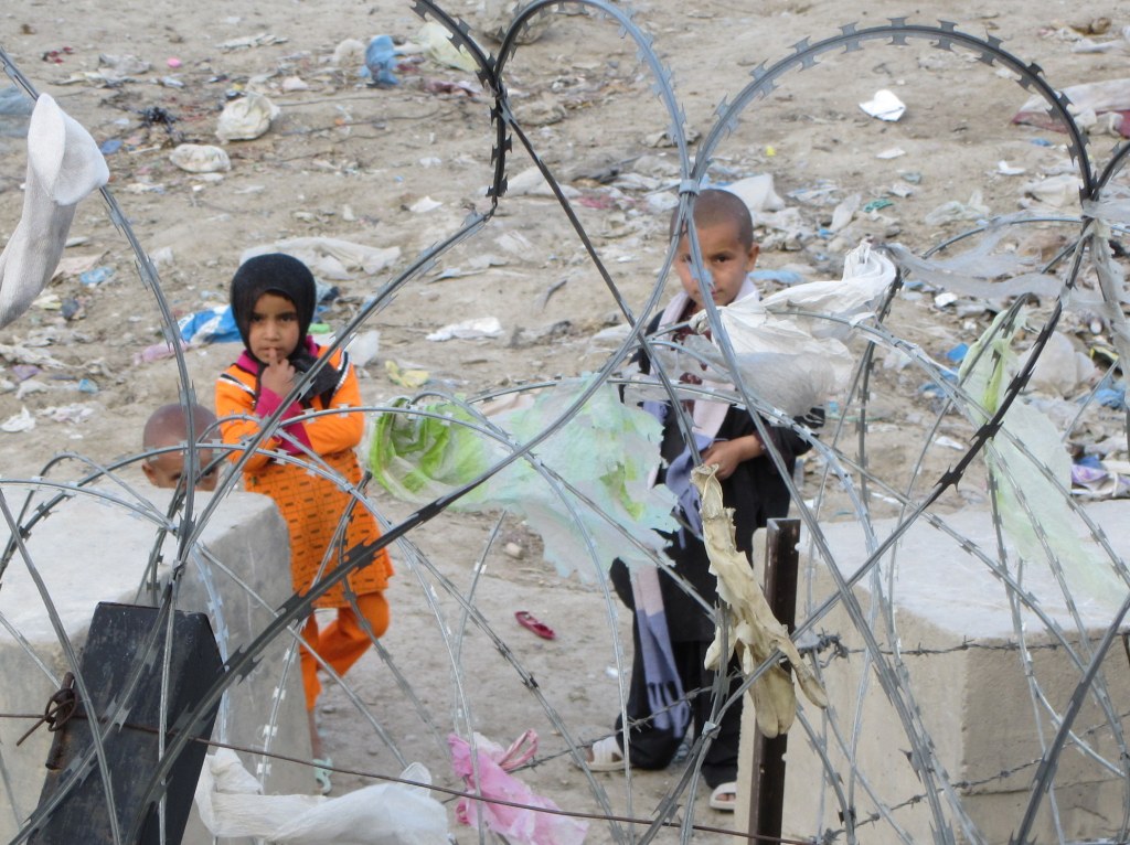 Children stood behind barbed wire.