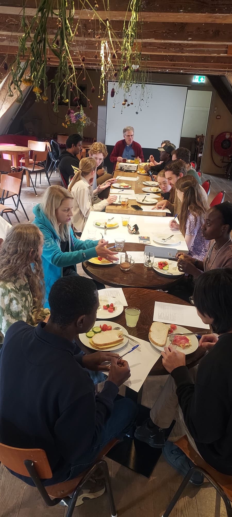 A group of young people having lunch sat round a table