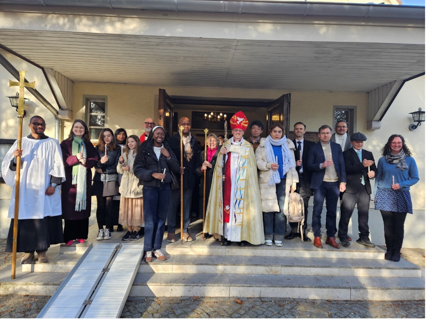 A congregation and a bishop outside a church