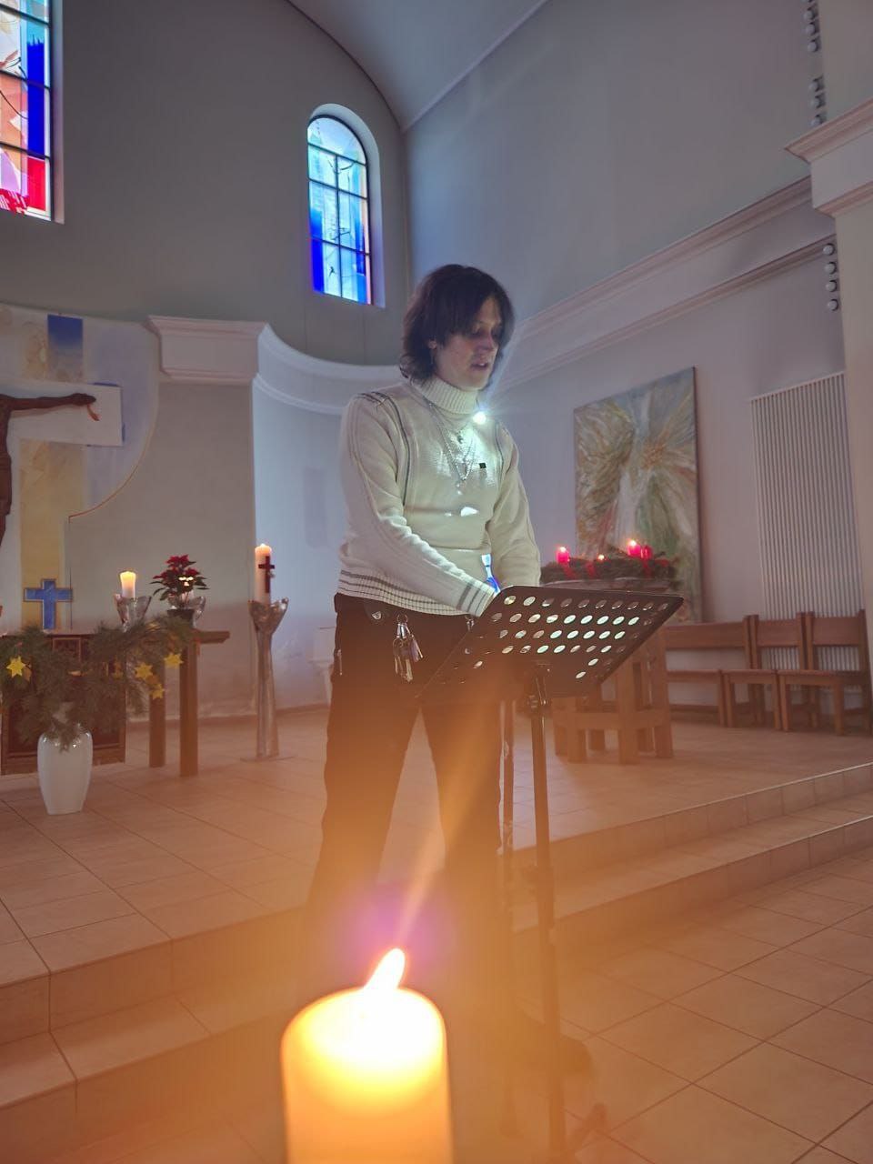 someone standing up giving a reading in a dark church