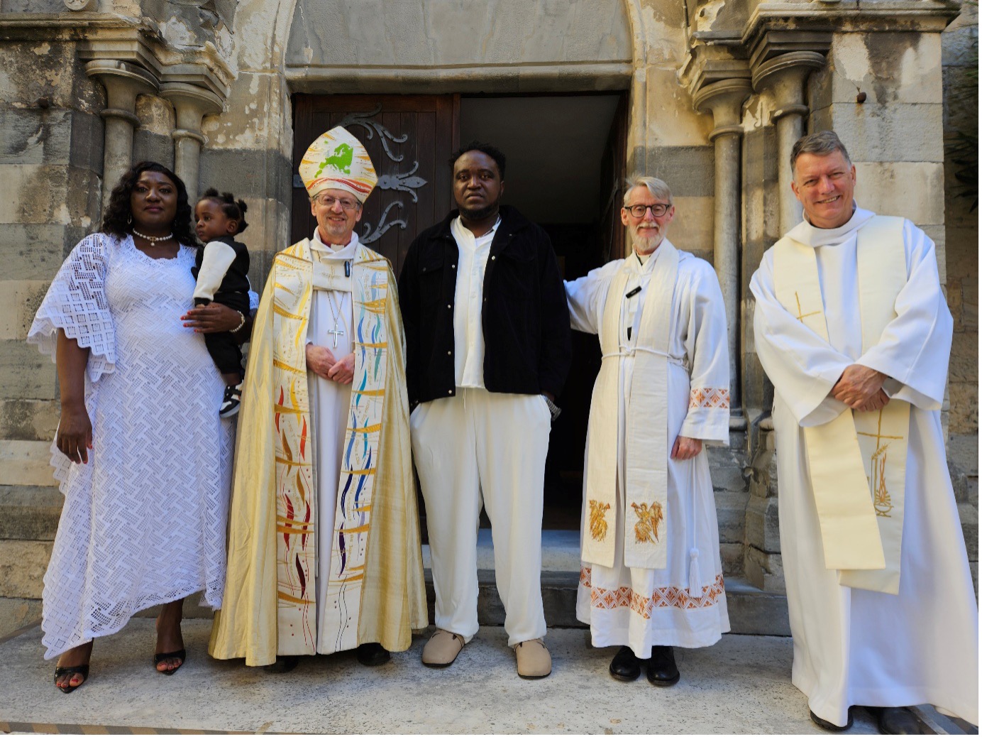 bishop and clergy outside a church