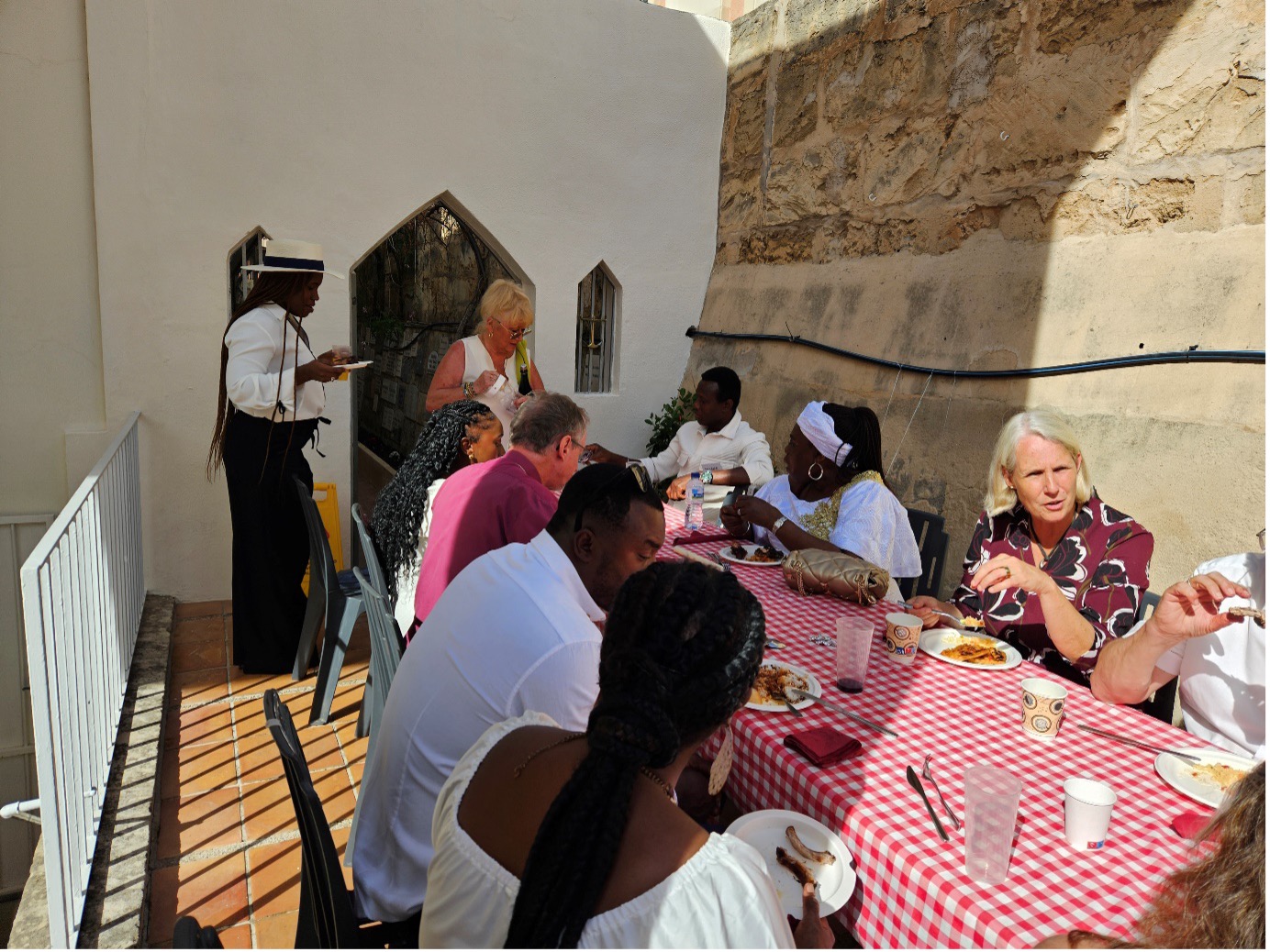 People eating round a table in the sun