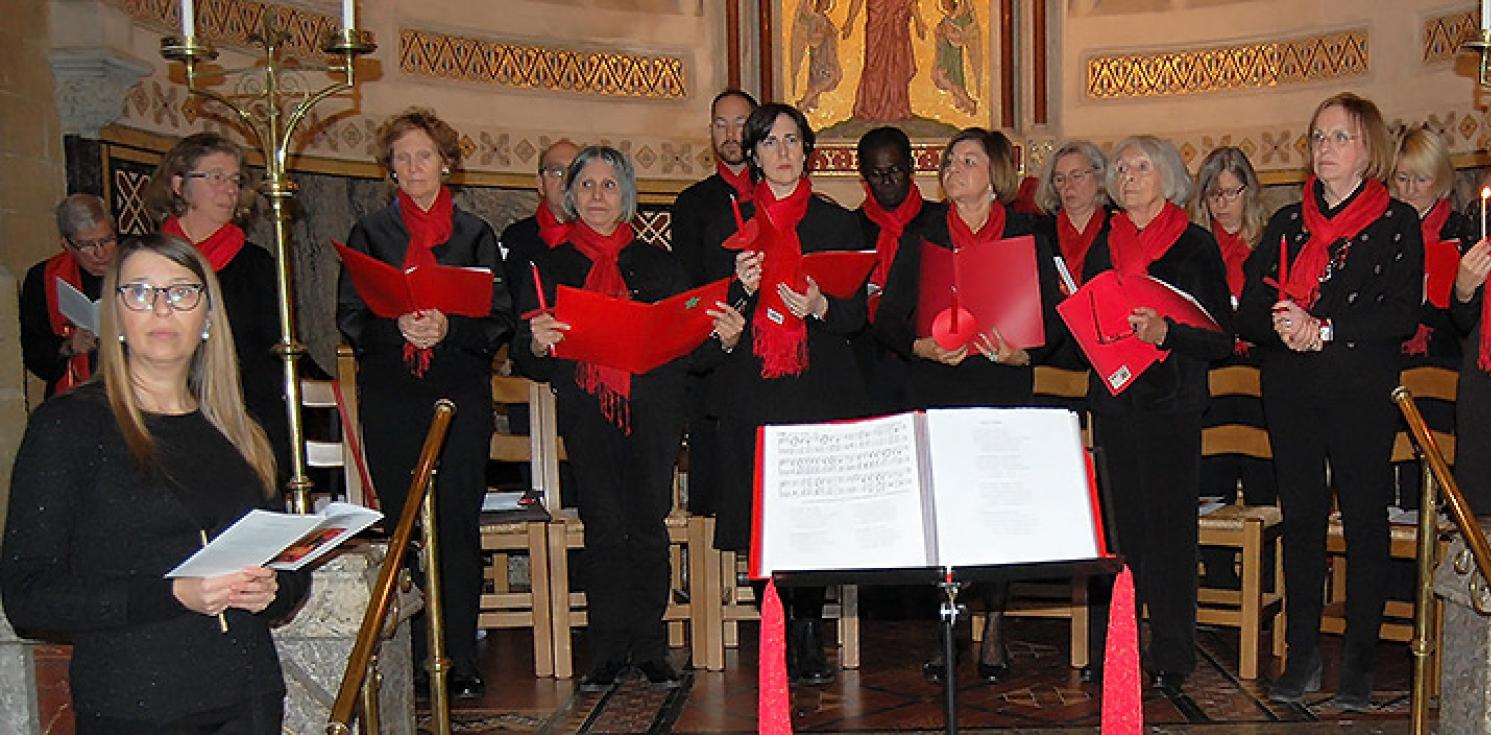 A choir group dressed in red and black stand ready to perform.