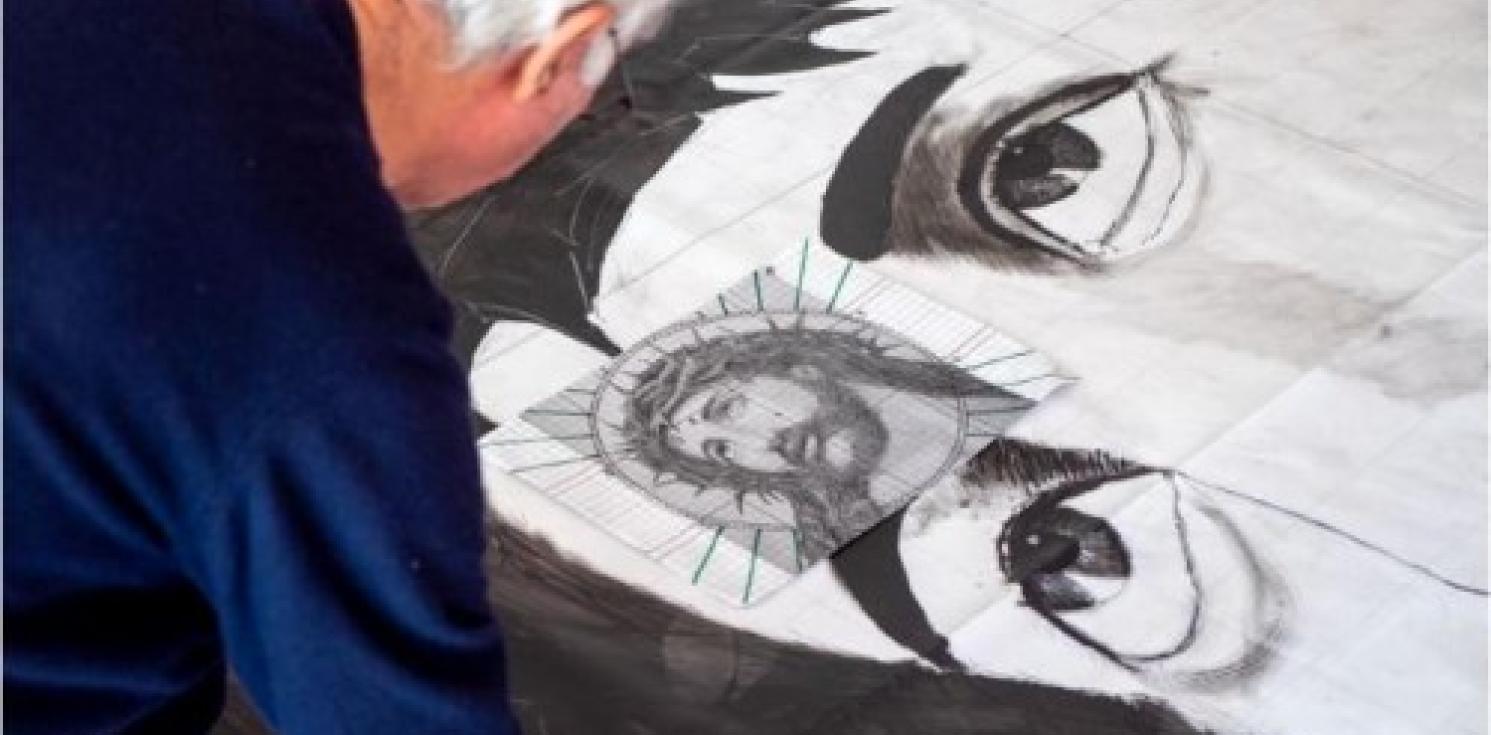 A man painting a black and white jesus.