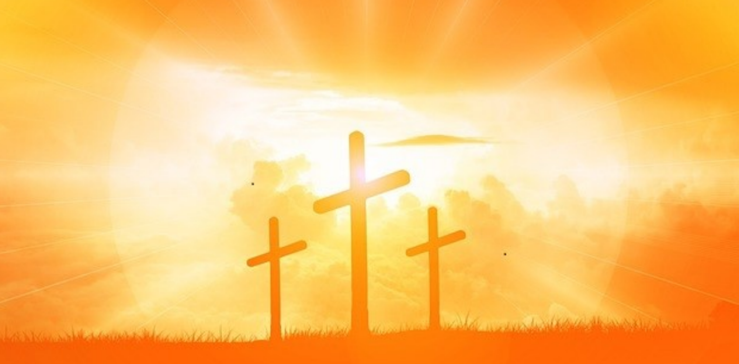 Three orange crosses on a hill.