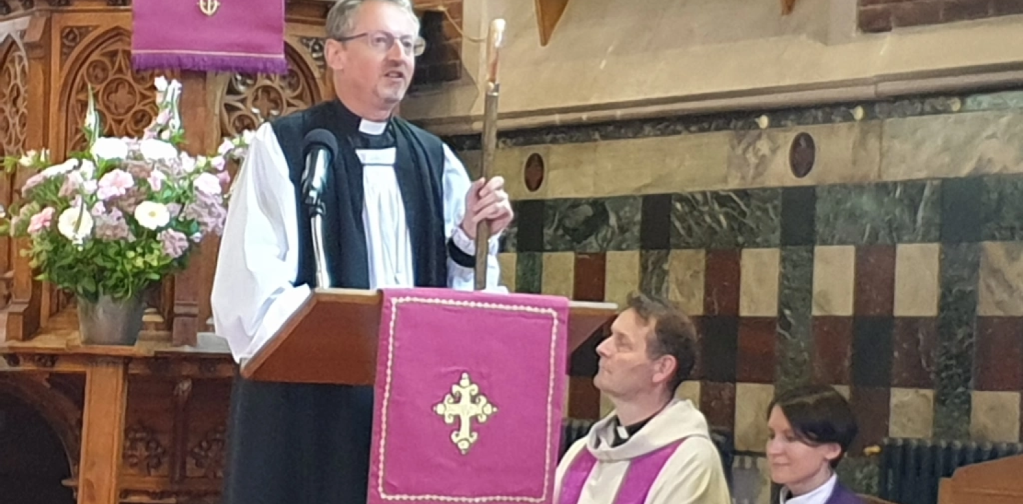 Bishop Robert speaking at the front of a church.