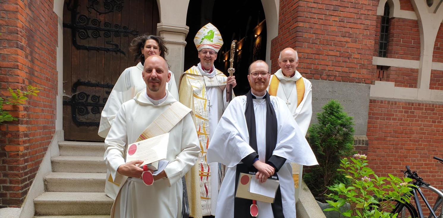 new ordinands standing on steps with bishop