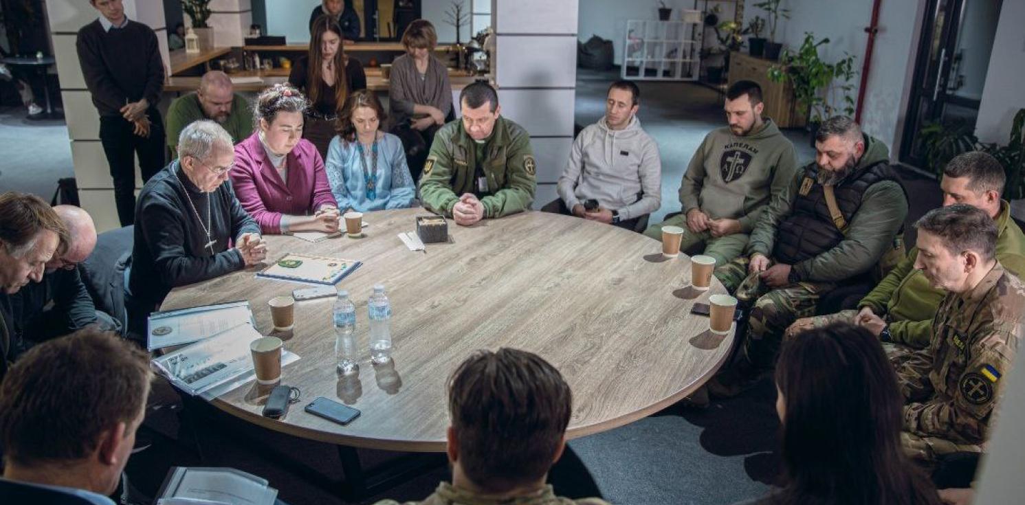 people sitting around a table, praying