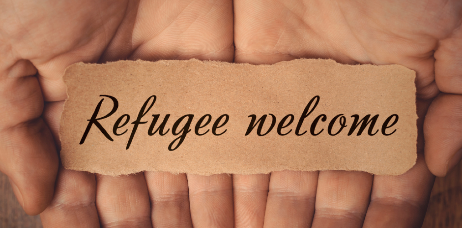 strip of paper with refugees welcome on it