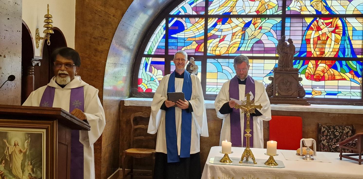 Three clergy conducting a service at the front of church