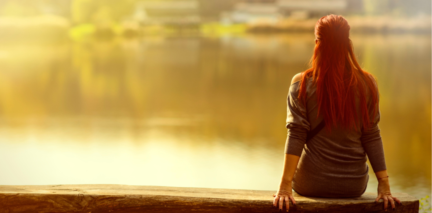 Person from behind looking at a lake