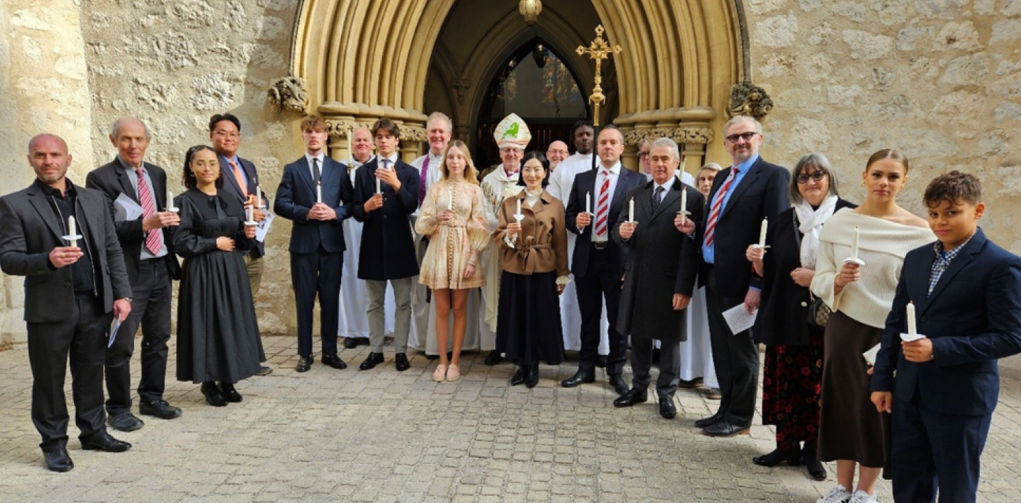 Row of confirmation candidates and Bishop Robert outside a church