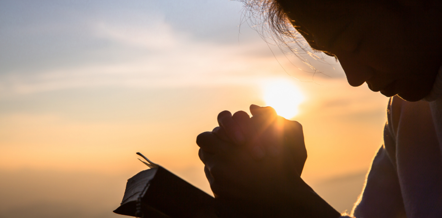 silhouette of someone praying