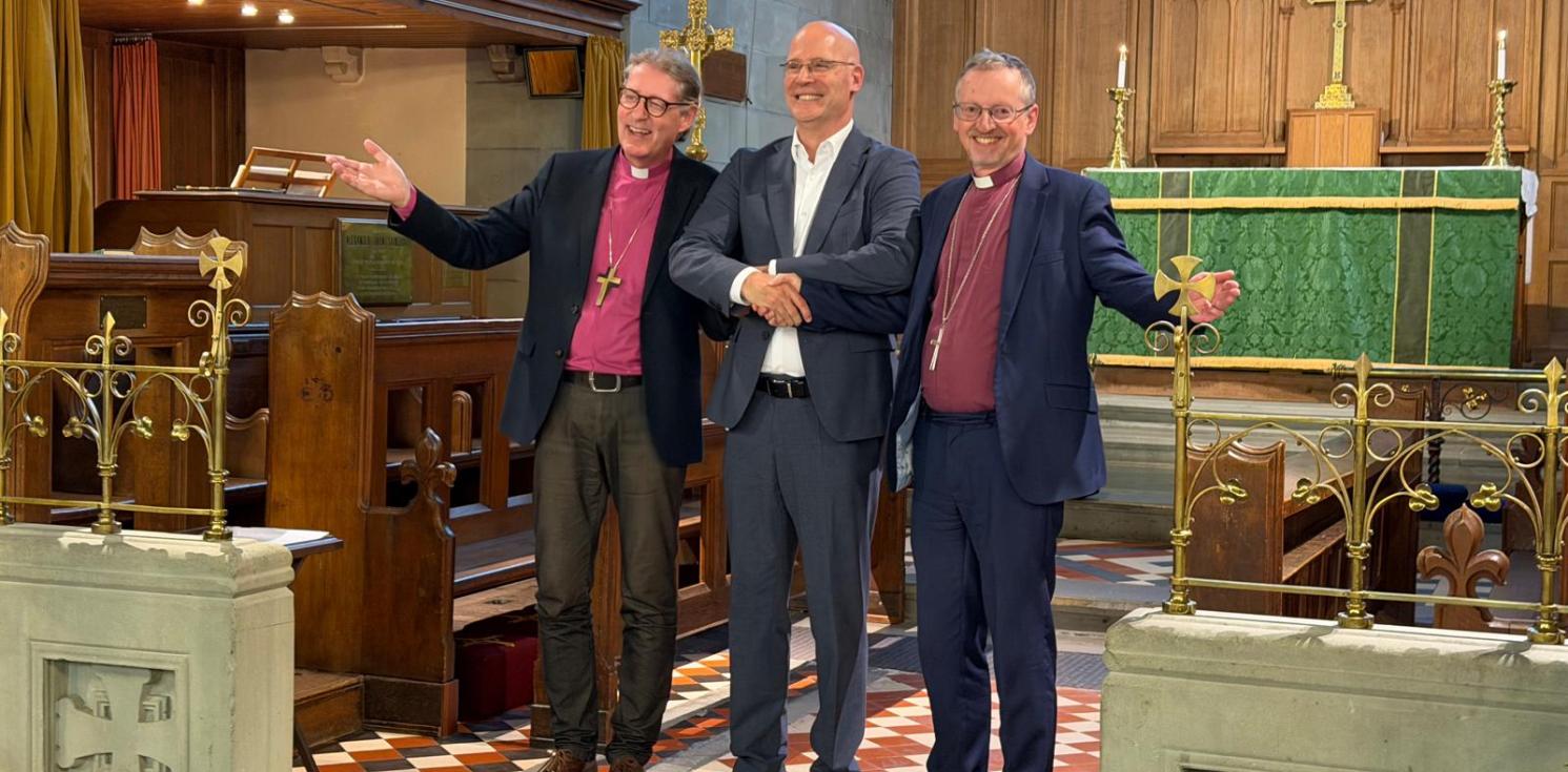 2 bishops and a man in front of an altar