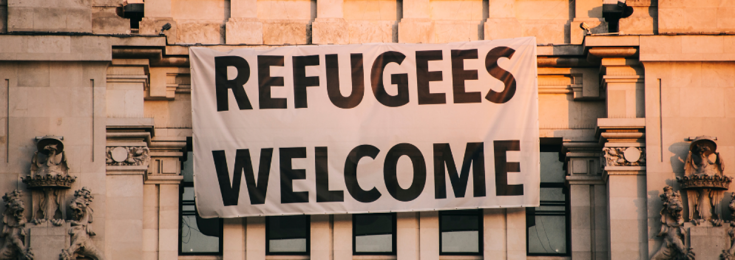 a sign on a building saying Refugees Welcome