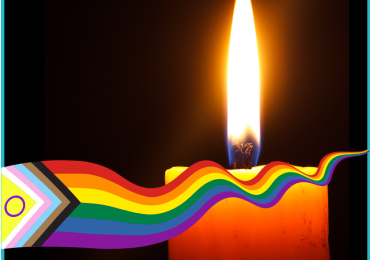 A lit candle behind an LGBTQIA+ ribbon