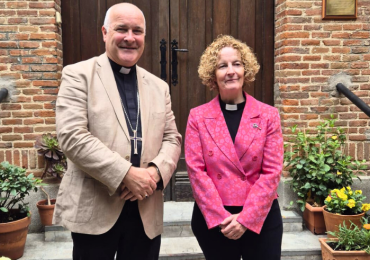 Archbishop and vicar in front of a church