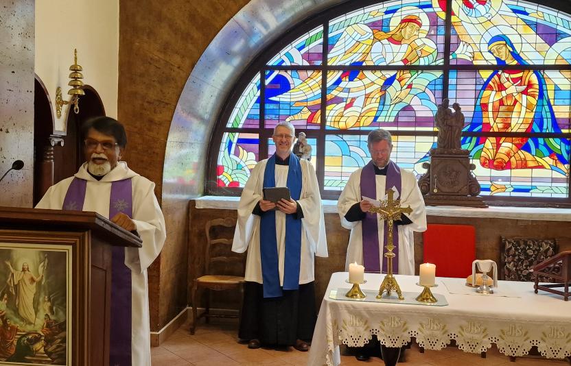 Three clergy conducting a service at the front of church