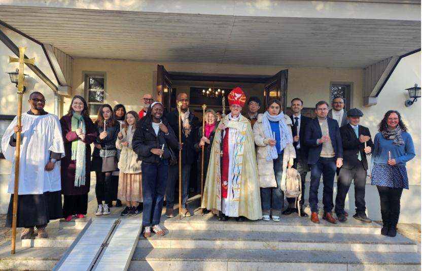 A congregation and a bishop outside a church