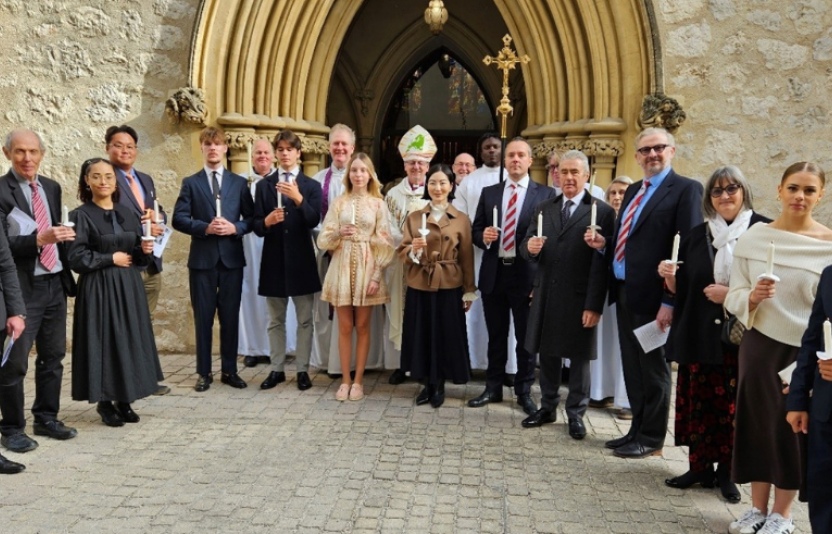 Row of confirmation candidates and Bishop Robert outside a church