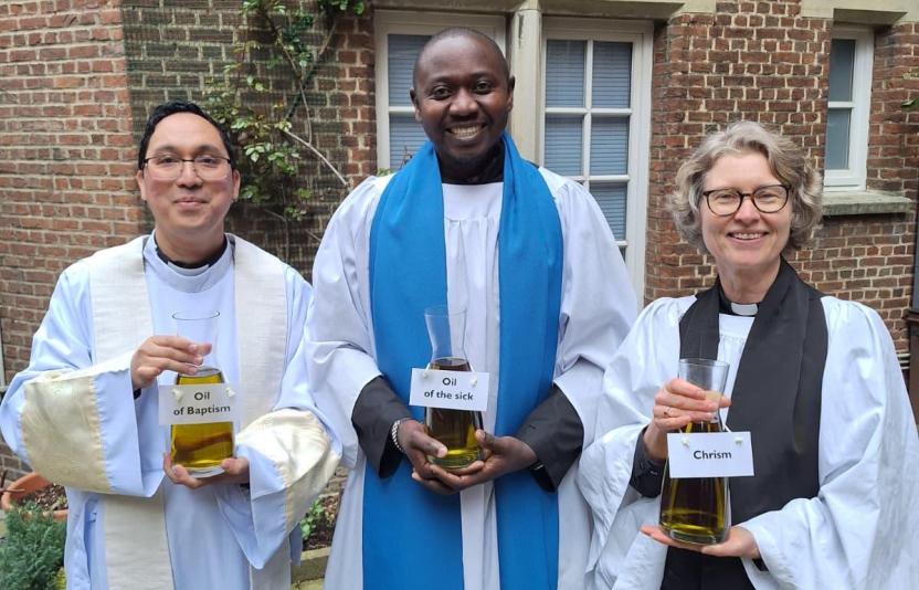 3 clergy in a row holding chrism oil
