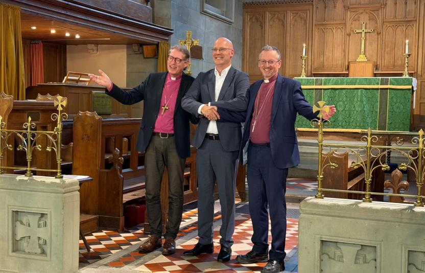 2 bishops and a man in front of an altar