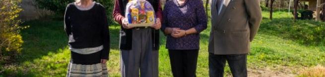 Three members of the Chaplancy and Revd Canon Denis Moss holding gifts.