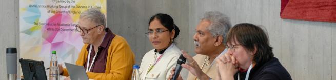 A panel of 4 with one of the speakers talking