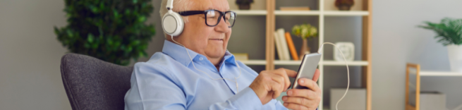 older man listening on headphones
