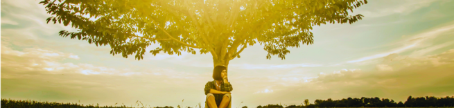 girl sits under a tree