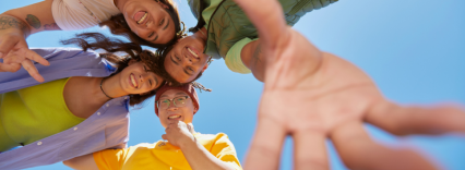 Group of youth looking down and reaching out