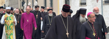 Priests from different traditions walk towards the camera up a road