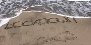 The word Lockdown written in sand.
