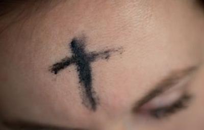 A girl with an ash cross drawn on her forehead.