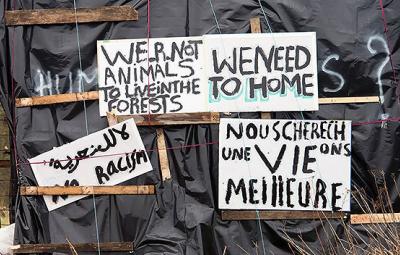 Signs made by migrants asking to be treated like humans.