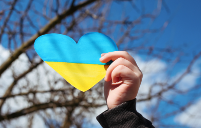 holding a Ukraine flag in a heart shape