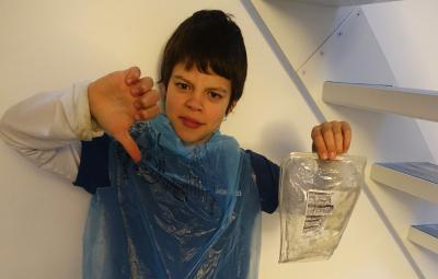 young boy with thumbs down and a plastic bag