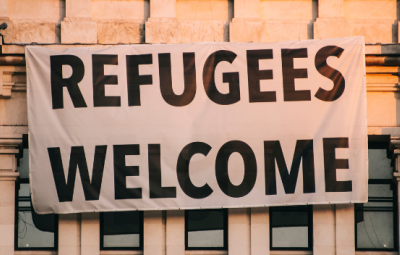 a sign on a building saying Refugees Welcome