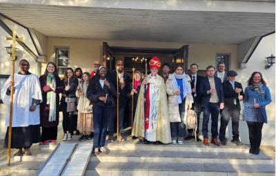 A congregation and a bishop outside a church